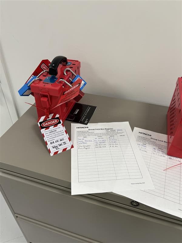 Group lock box secured with danger tags and padlocks during energized equipment lockout