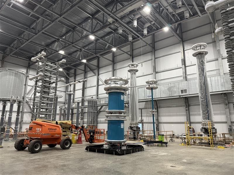 High-voltage test hall with HVDC equipment, corona rings, and construction lift