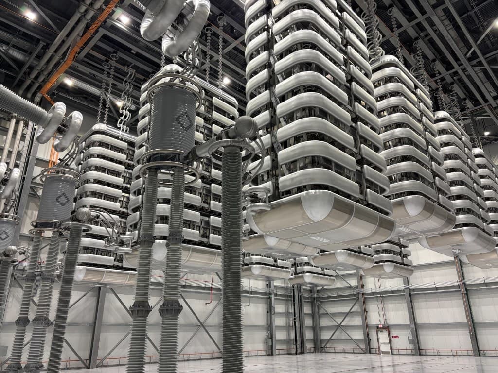 HVDC converter valve hall with valve towers, insulators, and overhead electrical infrastructure